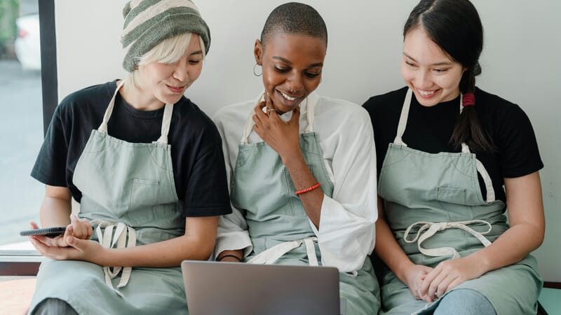 Waitresses using laptop together during a break